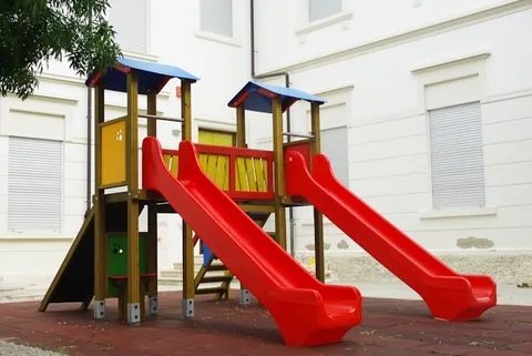 Poza cu un tobogan dublu pentru copiii in diferite culori